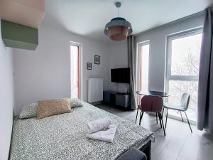a bedroom with a bed and a table with a chair at Ama Molto Apartments in Wrocław