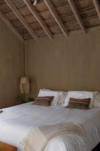 1 dormitorio con 1 cama blanca grande con almohadas en La Fragata, en Vichayito