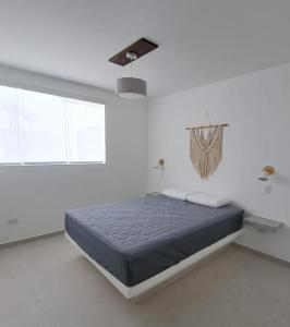 een slaapkamer met een bed in een witte kamer bij Casa de estreno en Playa Azul in Cerro Azul