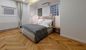 ブダペストにあるPedestrian apartment, the best locationのウッドフロアのベッドルーム1室(ベッド1台、窓2つ付)