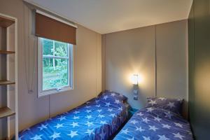 GasselteにあるSiblu De Lente van Drentheのベッド2台と窓が備わる小さな客室です。