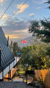una bandera canadiense ondeando junto a una casa con un banco en The overlook cottage en Batumi