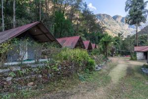 una fila de casas con montañas en el fondo en Borderlands Eco-Adveture Resort en Ghunthang