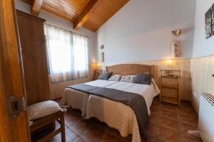 ein Schlafzimmer mit einem Bett und einem großen Fenster in der Unterkunft Casa rural Los Cántaros. Zarapicos in Zarapicos