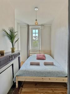 um quarto com uma cama e uma janela em Vue magique sur le château dans un quartier populaire em Pau
