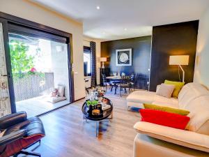 uma sala de estar com um sofá e uma mesa em Flamingo Apartment by Hello Homes Sitges em Sitges