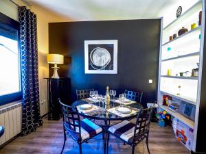 uma sala de jantar com uma mesa e cadeiras e uma parede preta em Flamingo Apartment by Hello Homes Sitges em Sitges