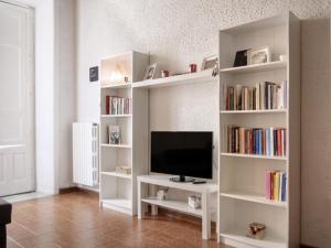 estante de libros blancos con TV en la sala de estar en Al Duomo, en Enna
