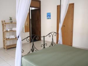 a bedroom with a bed with a green comforter at Al Duomo in Enna