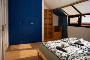 1 dormitorio con armarios azules y 1 cama grande en Delfin Bambi Los Gigantes, en Santiago del Teide