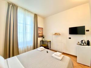 pokój hotelowy z łóżkiem i telewizorem w obiekcie i portici del centro w Como +3 zdjęcia