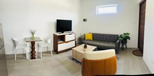 sala de estar con sofá y TV en Paraguana Inn, en Noord