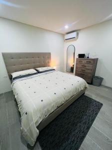 ein Schlafzimmer mit einem großen Bett und einem Spiegel in der Unterkunft Paraguana Inn in Noord