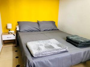 プエルトリャノにあるAcogedor apartamento muy cerca del centroの黄色い壁のドミトリールームのベッド1台分です。