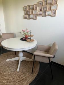 una mesa blanca con dos sillas y una mesa con flores. en Casa de Anne Steenwijk-Giethoorn, en Steenwijk