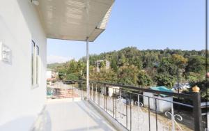 a balcony of a house with a view at Ram Homestay in Kangra