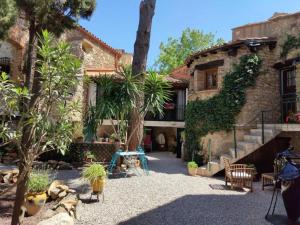 a house with a courtyard with plants in front of it at Les chambres du Mas Peu del Causse 