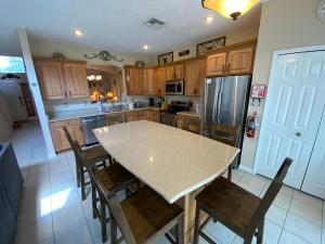 a kitchen with wooden cabinets and a table and chairs at Seasons Villa 6 bedrooms, 4 masters and water view in Kissimmee