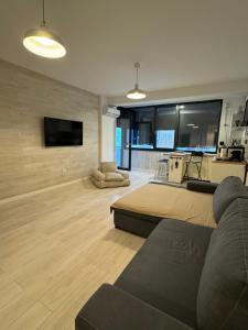 ein Wohnzimmer mit einem Sofa und einem Flachbild-TV in der Unterkunft Apartament 221 Mamaia Nord in Mamaia Nord – Năvodari