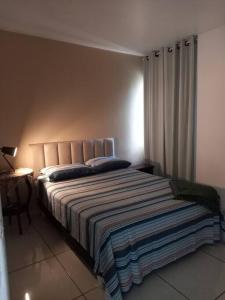 Un dormitorio con una cama con una manta a rayas. en Cantinho Côte d'azur Maceió, en Maceió