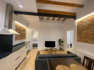 a kitchen and living room with a couch and a table at Poble Sec Charming Apartment in Barcelona