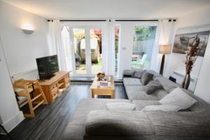 a living room with a couch and a tv at Bournemouth Hot Tub & Sauna Holiday Let in Bournemouth