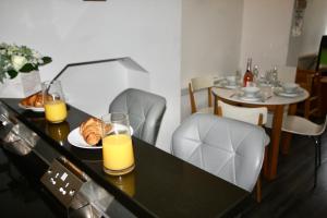 a table with two glasses of orange juice and croissants at Bournemouth Hot Tub & Sauna Holiday Let in Bournemouth