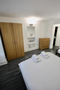 a bedroom with a bed with two towels on it at Bournemouth Hot Tub & Sauna Holiday Let in Bournemouth