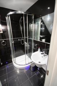 a bathroom with a shower and a sink at Bournemouth Hot Tub & Sauna Holiday Let in Bournemouth