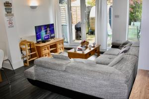 a living room with a couch and a tv at Bournemouth Hot Tub & Sauna Holiday Let in Bournemouth