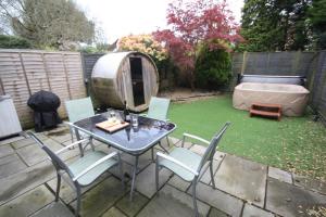 a patio with a table and chairs and a tent at Bournemouth Hot Tub & Sauna Holiday Let in Bournemouth