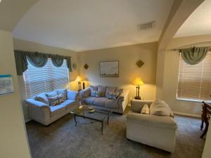 ein Wohnzimmer mit Sofas und einem Couchtisch in der Unterkunft Seasons Villa 6 bedrooms, 4 masters and water view in Kissimmee