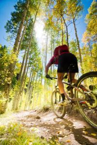 a person riding a bike on a dirt road at Zephyr Slopeside - 1504 condo in Winter Park