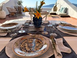 una mesa con un plato y un jarrón de flores en ANTICA DIMORA Santa Marina Salina en Santa Marina Salina