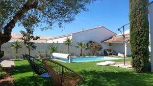 Un patio con piscina y una casa. en Maison avec piscine pour 4 adultes et 2 enfants, en Saint-Martin-de-Ré