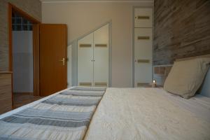 - une chambre avec un grand lit et un mur en bois dans l'établissement La maison, à Alcamo