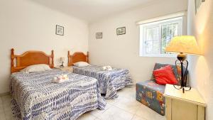 a bedroom with two beds and a chair and a window at Quinta de Sta Teresa by Villas Key in Lagoa +42 photos