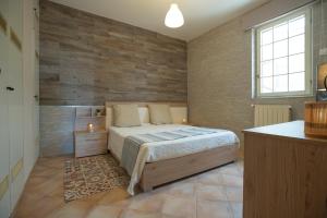 - une chambre avec un lit et un mur en bois dans l'établissement La maison, à Alcamo