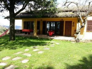 una casa con un patio verde con una mesa roja en Agriturismo Monte della Dea en Valfabbrica