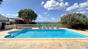 a swimming pool with chairs and an umbrella at Quinta de Sta Teresa by Villas Key in Lagoa