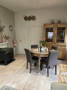uma sala de jantar com uma mesa e cadeiras e um fogão em Chalet Sint-Hubertus Du Bois em Zutendaal