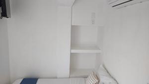 um quarto com paredes brancas e uma cama com almofadas em BAOS em San Blas