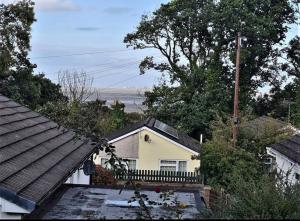 a white house with a fence and trees at Wenford Dorma Bungalow in Mostyn