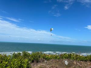 a kite flying in the sky over the ocean at Apto com Ar com vista para praia de Morro Branco - Fortaleza in Beberibe
