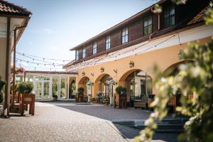 un patio vacío de un edificio con mesas y sillas en Ruunawere Hotel, en Nõmmealuse