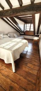a bedroom with a bed and a wooden floor at Casa del Lavadero in Santillana del Mar
