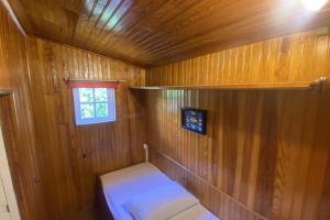a small room with a bed in a wooden cabin at Chalet Rive Bellacha near Ouistreham beach in Ouistreham