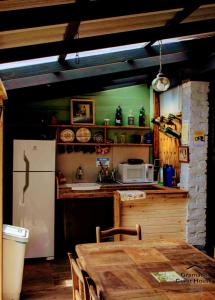 uma cozinha com uma mesa e um frigorífico branco em Gramado Guest House em Gramado