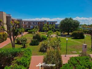 a park in front of a building with trees and bushes at La Terrazza in Noicattaro