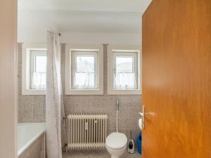 La salle de bains est pourvue de toilettes, d'une baignoire et de fenêtres. dans l'établissement Kurhaus am Nordenau - 10 pers, à Schmallenberg